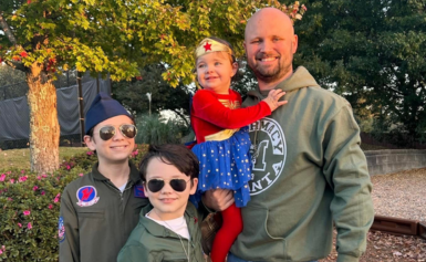 Bryan morgan with his three children, one dressed as wonder woman and the other two as military aviators.